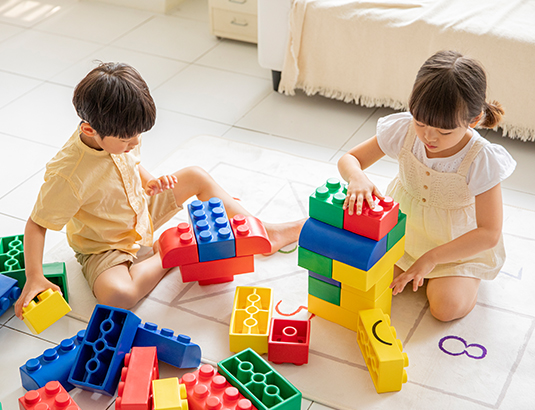 블럭을 가지고 놀고 있는 아이 2명